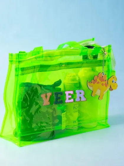 A neon green jelly chic bag, personalised with a name and a cute dinosaur charm.