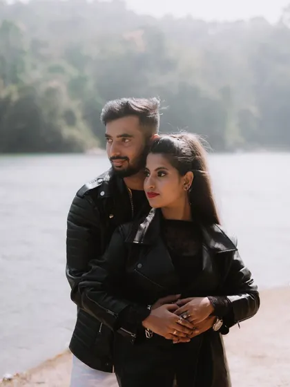 A portrait of a couple in matching leather jackets by a lake, perfect for an edgy pre-wedding shoot.