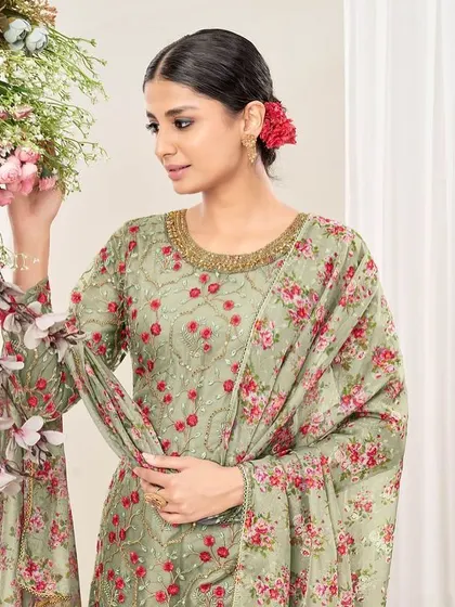 This pista green net suit is fresh and floral. The thread embroidery and printed dupatta with dhoti pants create a playful yet elegant look.
