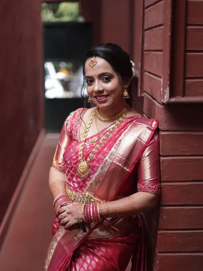 A beautiful portrait of the bride, showcasing her elegant makeup and the way it complements her pink and blue-green saree.