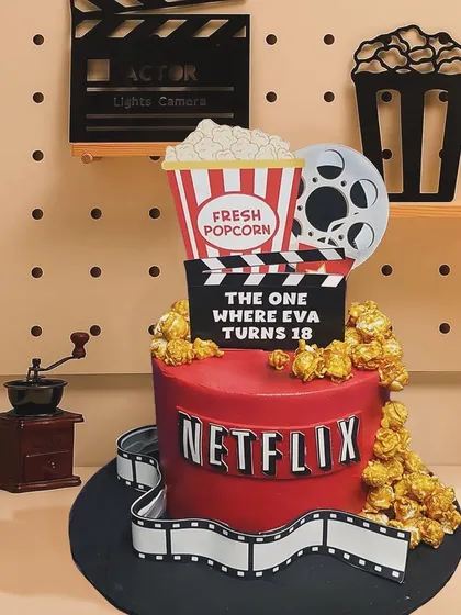 For the movie lover turning 18, this Netflix-themed cake is the perfect treat. It features an edible film reel, a bucket of fresh popcorn, and a clapperboard announcing "The One Where Eva Turns 18."