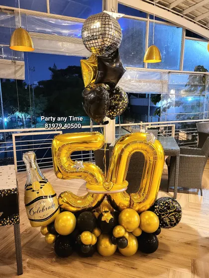 A fun 50th birthday balloon bouquet featuring a champagne bottle, disco ball, and large gold foil numbers.