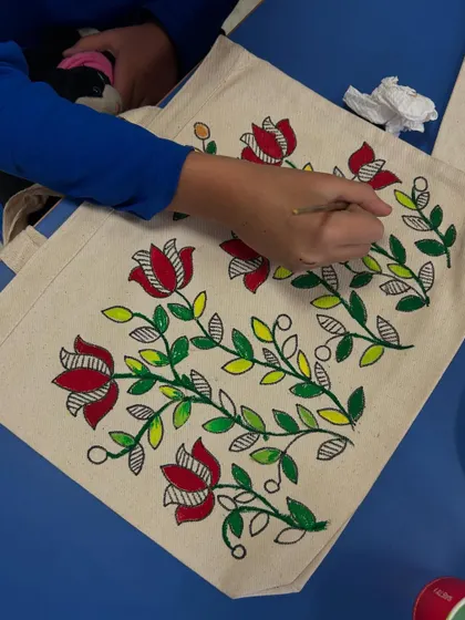 Here, a student is painting a beautiful floral vine pattern on their tote bag. This is another popular motif in Madhubani art.