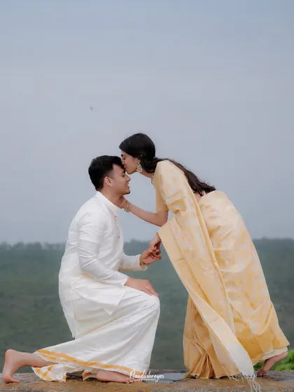 A tender moment as the bride-to-be kisses her partner's forehead after his proposal.