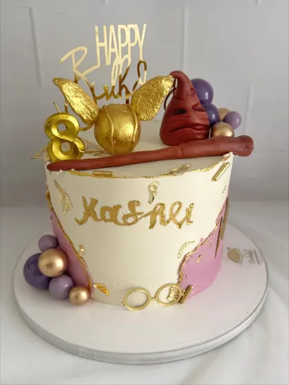 An elegant take on a Harry Potter theme, with a golden snitch, wand, and purple and gold accents.