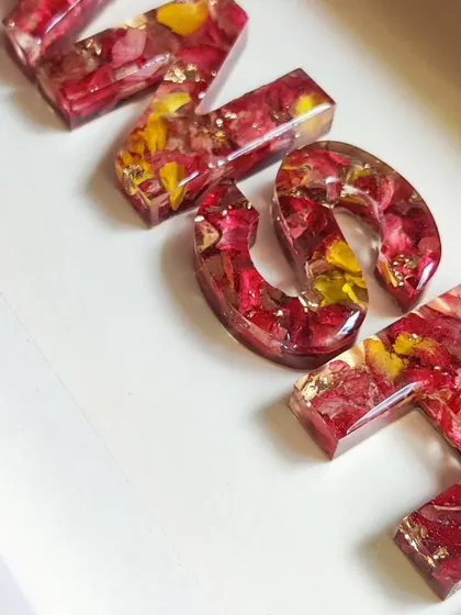 A macro shot of the resin letters, highlighting the texture and detail of the preserved flowers. This is what makes each piece so unique.