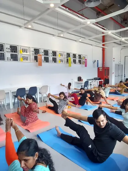 A dynamic boat pose variation during a corporate class. This pose is excellent for building core strength and focus.