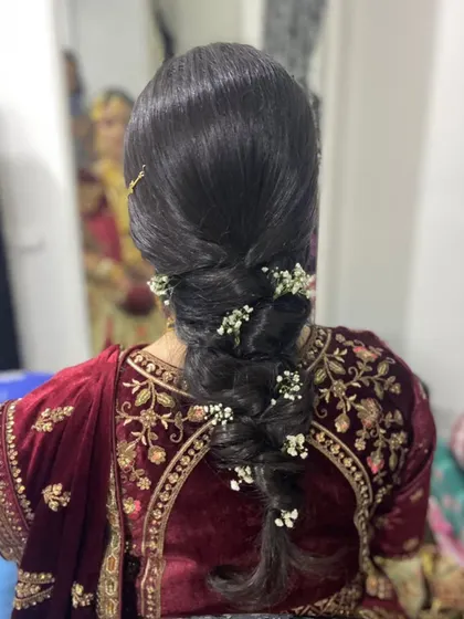 An elegant and intricate bridal braid, woven with sprigs of baby's breath for a delicate and romantic feel.
