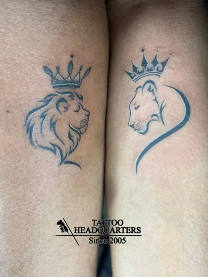A couple's tattoo of a lion and lioness, each wearing a crown, symbolizing a royal partnership.