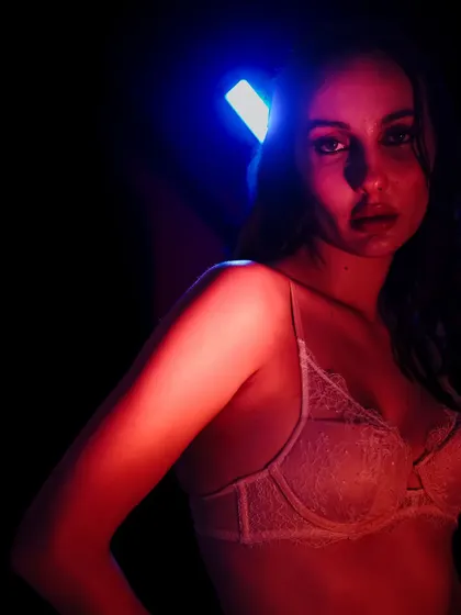 A close-up portrait where the colored lights create a painterly effect on the model's face and shoulders.