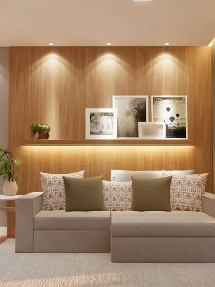 A cozy living room setup with a comfortable sofa-cum-bed and a floating shelf with backlighting, perfect for displaying photos and decor.