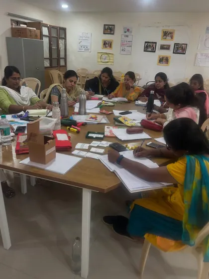 A group of educators at Cambridge School deeply focused on a written task during a workshop. The session combines hands-on activities with moments of quiet reflection and planning.