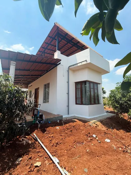 This side view highlights the home's clean geometric lines and the contrast between the white walls and the dark-framed windows. Even in a modern design, we ensure the home sits comfortably in its natural surroundings.