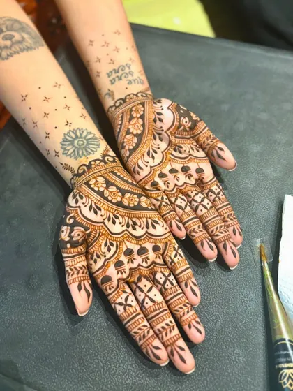 A simple yet beautiful wedding mehendi that incorporates the client's existing tattoos. I can work with you to create a design that complements your personal style.