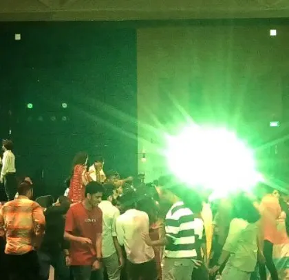 The party is in full swing, with green spotlights on the dance floor.