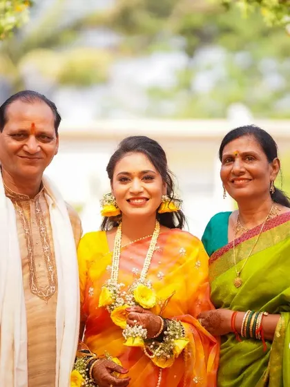 A precious family portrait with the bride during her Haldi. Her bright smile, flanked by her proud parents, makes for a beautiful memory.