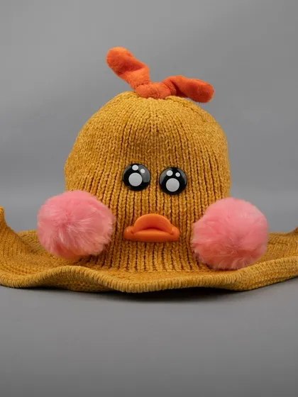 A front view of the mustard-yellow duck hat, showing its cute face.