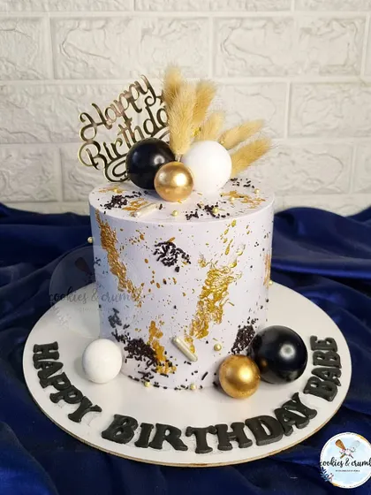 A popular design for milestone birthdays like 50th or 60th. This cake uses a palette knife technique with black, white, and gold, topped with dried botanicals for a rustic yet modern feel.