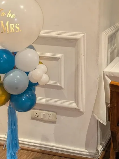 A close-up of the blue, white, and gold balloon centerpiece with a custom 'Soon to be Mr. & Mrs.' message.