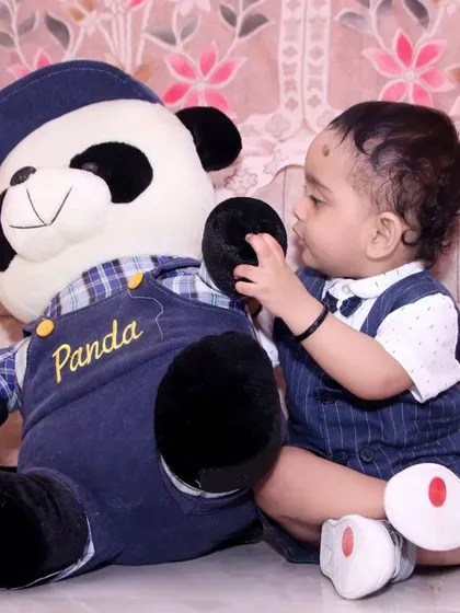 A simple, at-home version of a milestone shoot, showing the baby playing with his favorite teddy bear.