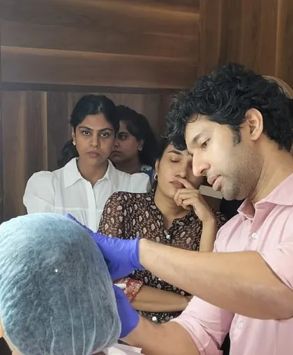 A close-up of a hands-on thread lift demonstration. My goal when training other doctors is to impart the precision and artistry required to use these tools for effective facial contouring and rejuvenation.