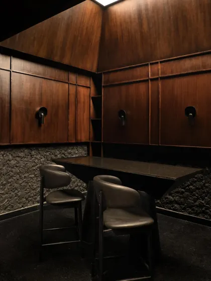 A private, wood-paneled tasting room within Lair, offering a sanctuary of warmth amidst the cool concrete. The space is designed for intimate gatherings, with its own taps for a bespoke experience.