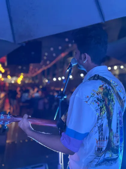 A shot from the back, looking out at the audience at a lively venue. The fairy lights and the crowd create a magical atmosphere for a live music night.