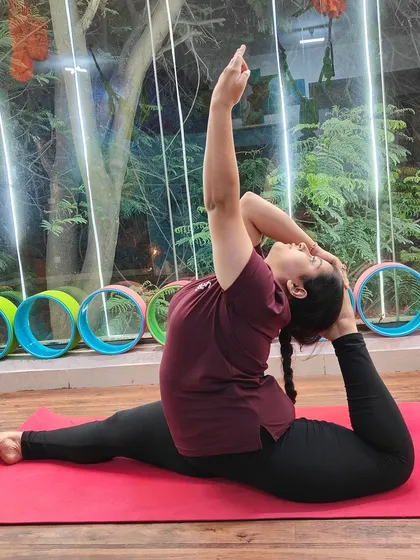 A student in Eka Pada Rajakapotasana (One-Legged King Pigeon Pose), a deep backbend and hip opener.