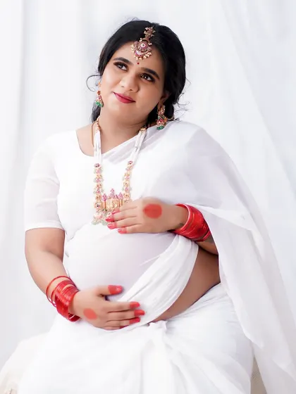 A serene and angelic maternity shoot. The all-white theme is complemented by soft, natural makeup and traditional jewelry, creating a timeless and pure look.