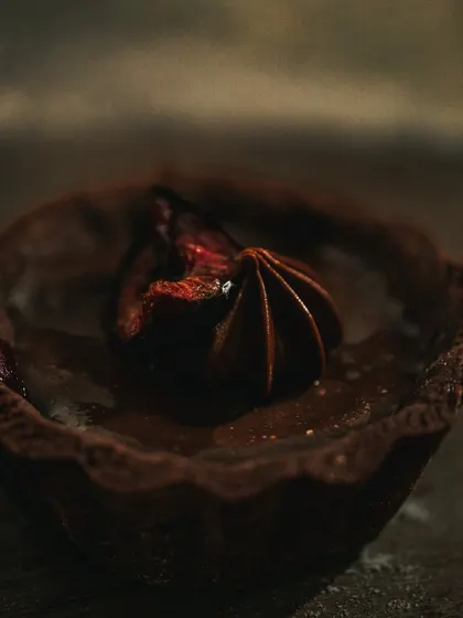 A close-up of the chocolate tart with a vintage feel, using warm tones and soft focus.