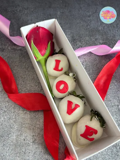 A close-up of our "LOVE" strawberry box. Each strawberry is dipped in white chocolate and decorated by hand, making for a beautiful and delicious romantic gift.