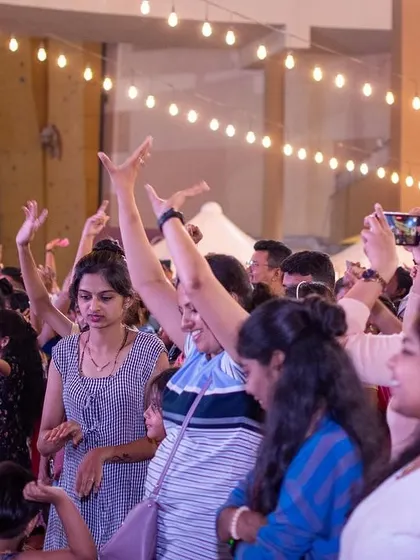 The crowd with their hands up, fully engaged in the live music experience.