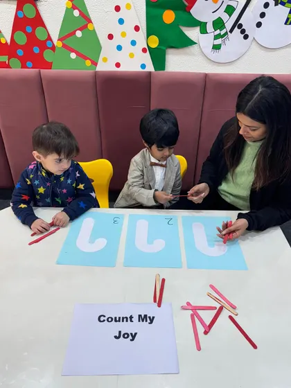 Two boys work together on their Christmas counting task. Collaborative learning activities like this not only build math skills but also encourage teamwork and communication.