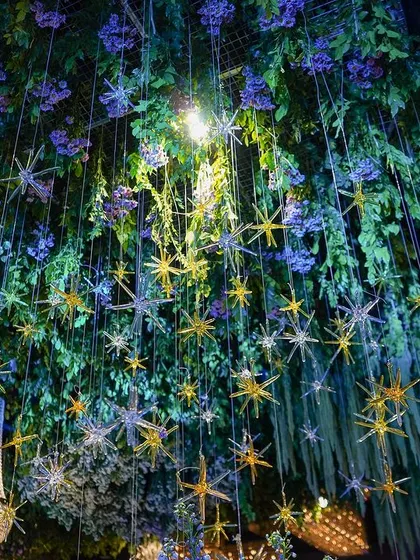 Another shot looking up at the celestial-themed ceiling, with its dense canopy of greenery and a galaxy of hanging stars.
