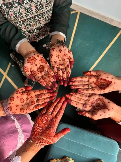Another group photo showcasing a variety of festive henna styles, from simple butis to more detailed patterns.