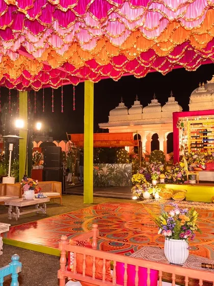 A wider view of the colorful Mehendi event, with a custom-printed dance floor and bright overhead decor creating a festive explosion of color.