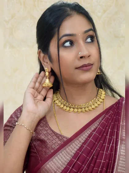 A classic gold coin necklace (kasu mala) that is perfect for any traditional silk saree.