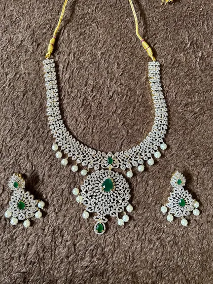 A delicate CZ stone necklace with a green center stone and pearl drops. This set is a great rental for bridesmaids or for attending a wedding.