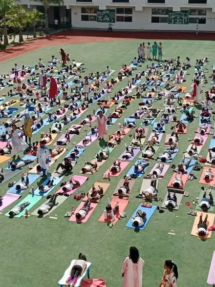 Students perform a resting yoga pose, learning the importance of relaxation and mindfulness as part of a balanced yoga practice.