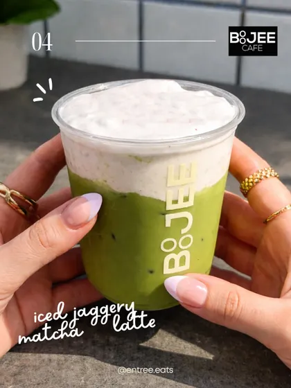 An Iced Jaggery Matcha Latte from Boojee Cafe. This shot, held in hand, gives a personal, on-the-go feel, making it relatable for cafe hoppers.