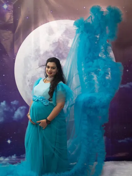 The detachable trail on this blue ruffle gown adds versatility, allowing for different looks during your indoor or outdoor maternity shoot.