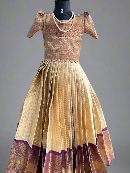 Another beautiful kids' lehenga crafted from a semi-Kanchi saree. This one combines a classic beige and purple, with a traditional brocade blouse and a pleated skirt that's perfect for twirling.