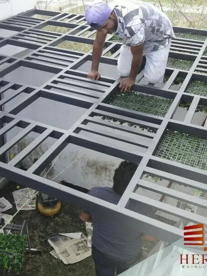 Here you can see my team carefully installing the framework for a large glass and metal pergola. We ensure every structure is built with precision and high-quality materials for safety and durability.