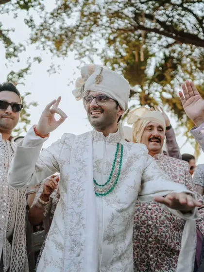 A candid shot of the groom and his party dancing and celebrating during the wedding procession.