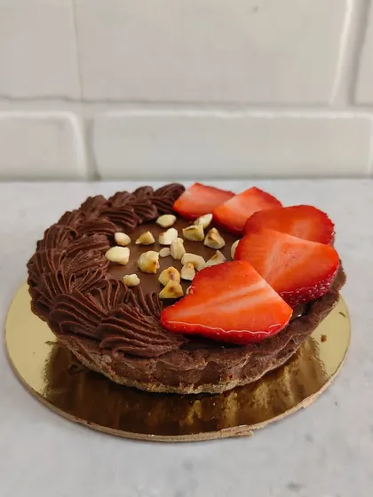 A mini chocolate tart topped with fresh strawberries and hazelnuts. A perfect little treat for one or two people.