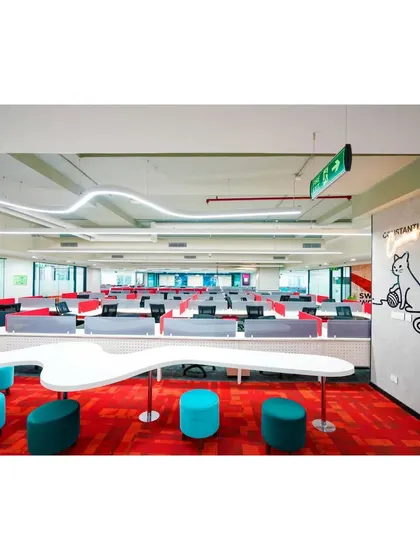 At Mindsprint, we designed this collaborative hot-desking area with a custom-shaped table and colorful stools. The space is defined by a unique overhead light fixture and playful wall graphics, encouraging spontaneous meetings and creative exchanges.