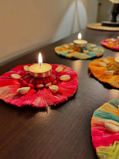 A close-up of the warm, festive glow from one of the lit macrame diya holders.