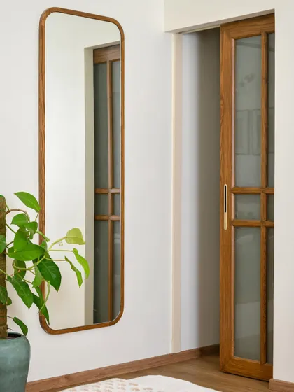 An open-shelf walk-in wardrobe in 'House of Kismish', accentuated by a striking wood and glass sliding shutter. This design element becomes a highlight of the room.