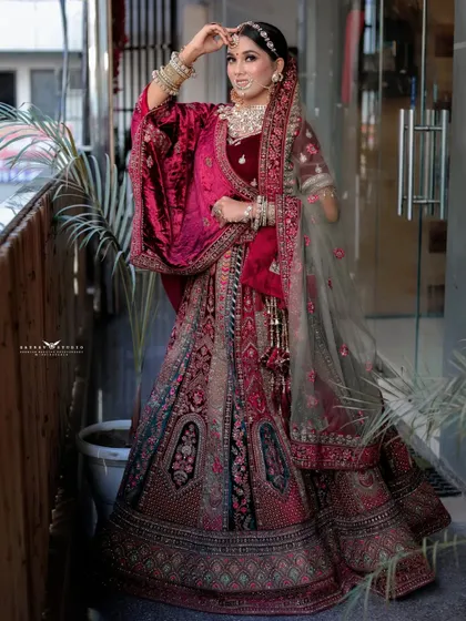 A celebratory pose with the bride looking up and smiling. This full-length shot perfectly captures the grandeur of her wedding lehenga and her joyful spirit.