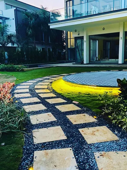 A pathway made of square stone pavers set in dark gravel. This style of path is modern, durable, and allows for water permeability.